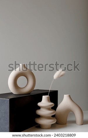Beige ceramic vases on light background. Spa still life with vases and candle. Hygge concept, cozy home, scandinavian design, copy space. Minimalism and modern decoration