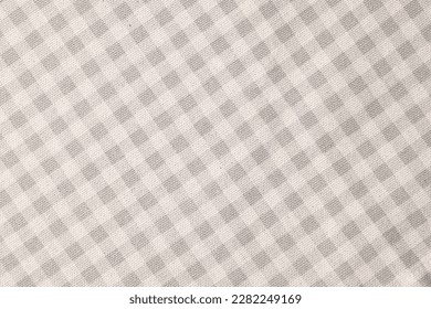 Beige checkered tablecloth as background, top view