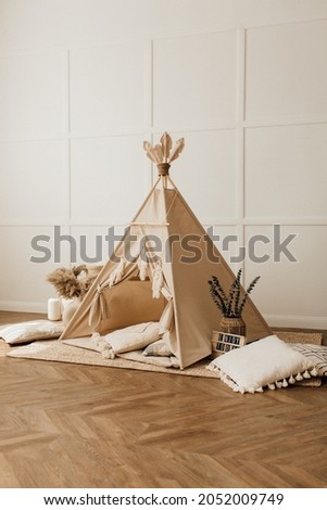 beige children's wigwam in the room on the floor Scandinavian style with decor