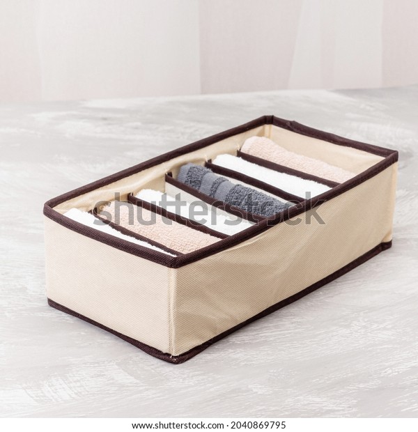 Beige closet organizer\
with towels. Storage organization. Order and cleanliness. Neatly\
folded towels