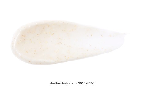 Beige color scrub cream with orange pigment stroke on background