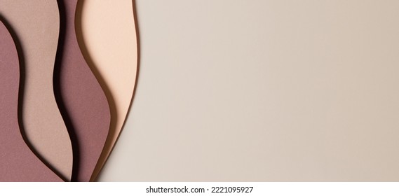 Beige colored paper texture background. Minimal paper cut style composition with layers of geometric shapes and lines in shades of brown colors. Top view