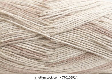 Beige cotton and linen mixed yarn skein texture close-up. Spring and summer season knitting.