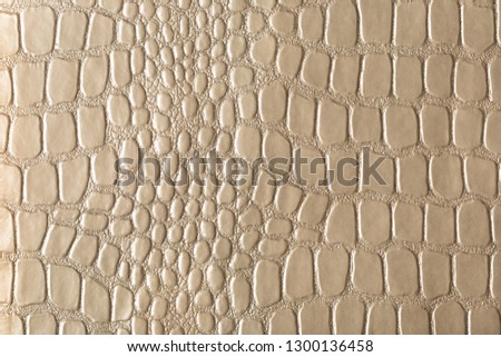 Beige, gold, glamorous croc-embossed artificial leather. For background and design.