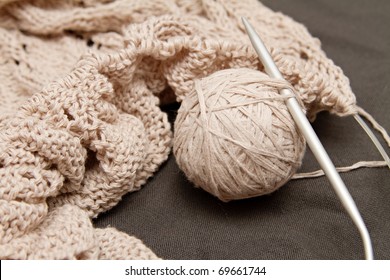a beige knitted shawl with round needles