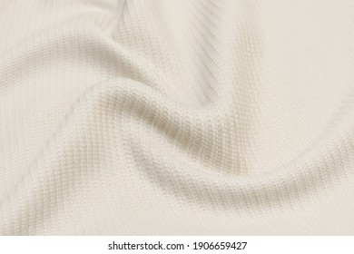 Beige knitted woolen background. Knitwear fabric texture.