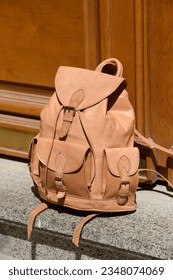 beige leather oldfashioned backpack. outdoors photo