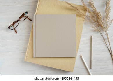 Beige Leather Photo Album Or Notebook Cover Mockup, Flat Lay Composition With Photo Albums, Pencils, Glasses And Dried Plants.  