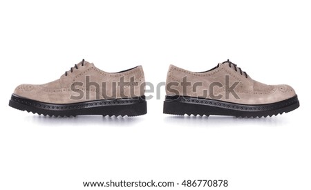 The beige light female shoes in grunge style suede. The sole black. Shoes with laces. White studio background.