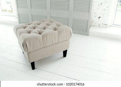 Beige Ottoman In A Bright Room Near The Window. Element Of A Decor Of A Stylish Interior. Modern Living Room Interior With Furniture. Concept Interior Things Copy Space. Selective Focus