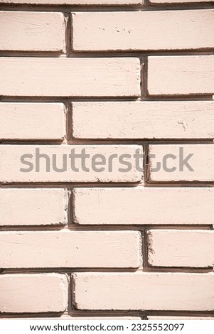 Beige painted bricks texture, vertical. Peach color brick wall for background. Light pinkish brick wal closeup. Loft design underlayer.  