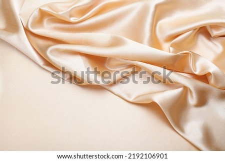 Beige pearl wave silk fabric. Abstract texture horizontal copy space background.