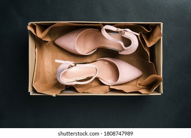 Beige Shoes In A Rectangular Box On A Black Background. New Womens Shoes With A Clasp In The Package. Womens Fashion. A Top View Of A Flat Layout.