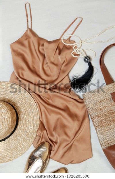 Beige silk slip dress with accessory, top view.\
Simple elegant summer\
outfit.