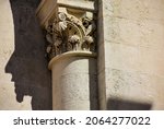 beige stone column head in neo romanesque style. stone textures. fine details of sculpting. religious architecture. faith and religion concept. architectural detail. travel and tourism. Pecs, Hungary.