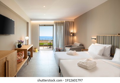 Beige striped and light wood interior of modern minimalistic style double hotel room with open French window and sea view