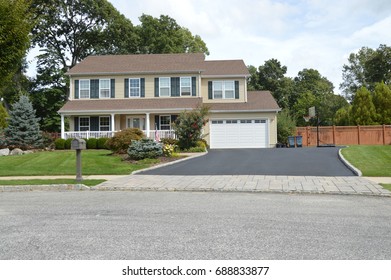 Beige Suburban High Ranch Home With Two Car Garage And Blacktop Driveway USA