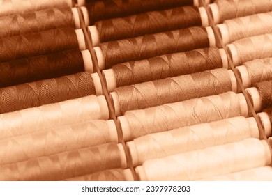 Beige threads lying in a box. Concept of hobbies and handmade. Demonstrating peach color of 2024 year.