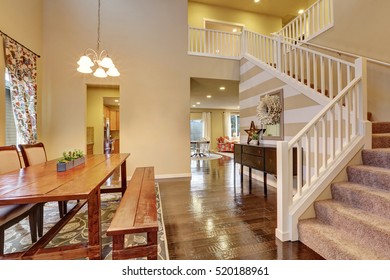 Beige Tones Dining Area With Rustic Wooden Table And Bench, Polished Hardwood Floor, Contrast Striped Wall And  Staircase . Northwest, USA