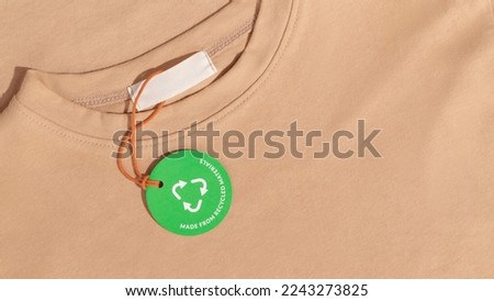 Beige tshirt and Green paper label with inscription 