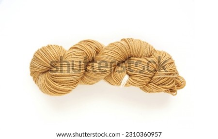 Beige twisted yarn hank on a white background, hand dyed wool skein flat lay top view