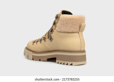 Beige women's fashion combat boot isolated on white background. Female classic autumn Timberland shoe. Leather laced, lace up casual footwear with metal rivets, rough sole, fur outside. Behind view - Shutterstock ID 2173783255