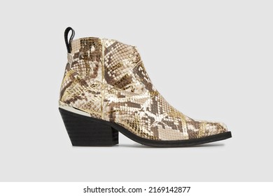 Beige women's fashion cossack Cowboy boot in python snake skin leather isolated on white background. Female classic spring autumn shoe with Pointy Toe, heel. Casual footwear in animal print. Mock up