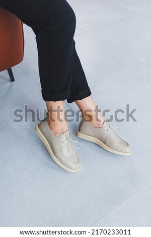 Beige women's leather shoes close-up on female legs. New collection of women's summer leather shoes.