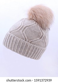 Beige Wool Knit Ski Hat With Faux Fur Pompom Isolated On White. Bobble Hat Topped With Pom Pom Or Loose Tassels. Knit Cap Folded Brim. Knitted Warm Hat. Tuque Or Toque Outdoors Headgear