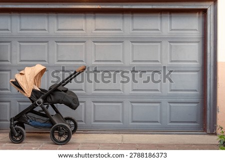 beige-black empty stroller in front of garage door.