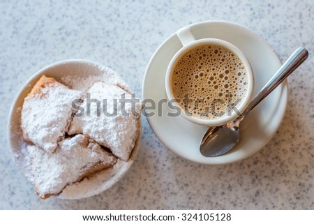 Beignets (French style donuts) topped with sugar and a cup of coffee in the background Stock fotó © 