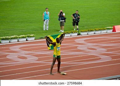 BEIJING - AUGUST 18: Usain Bolt celebrates holding the Jamaican flag after setting new world record  for men's 100 meter sprint at the 2008 Summer Olympic August 18, 2008 in Beijing, China.