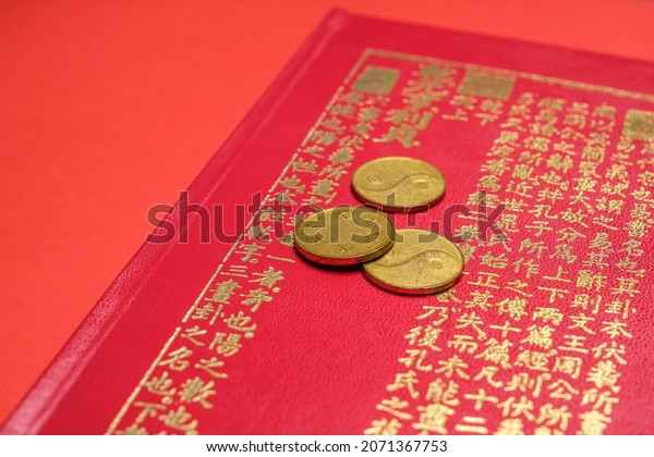 Beijing,\
China, 08-11-21: I ching ancient Chinese oracle, Book of Changes or\
Classic of Changes with old coins\
close-up