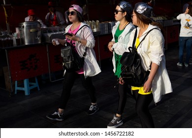 Beijing / China - April 12 2016: Millenial Women With Matching Colorful Outfits Walking On The Street