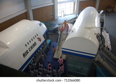 BEIJING, CHINA – APRIL 14 2015: Unidentified Air China Cabin Crew Members Prepare To Train For An Aircraft Evacuation On Land Using Emergency Slides At The Airline's Training Facility In Beijing.