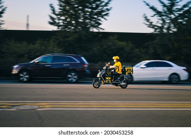 Beijing, China - August 21, 2021: Chinese Food Delivery Man From One Of The Largest Ecommerce Platforms Meituan Is Seen On A Motorbike In Beijing.