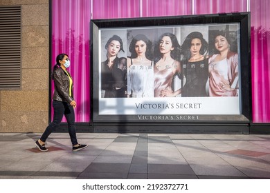 Beijing, China - August 21, 2022: Woman Wearing Mask Passing By Victorias Secret Advertisement Billboard Located In Downtown Beijing.