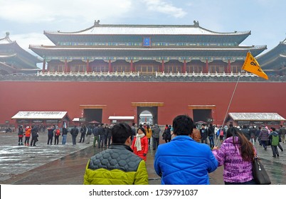 Beijing, China - December 20, 2012: 
Local Tour Guide Holding Tour Guide Flag Leading Chinese Tourists Into Meridian Gate, Forbidden City.