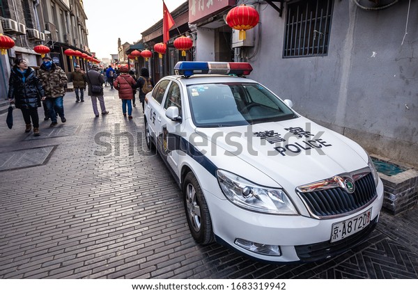 Beijing,\
China - February 8, 2019: Police car in traditional residential\
area called hutong in Xicheng area Beijing\
city