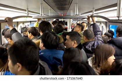 BEIJING, CHINA - JAN. 12, 2014: Crowded subway train during rush-hour. Any subway trip, costs only 2 yuan (33 US cents); Beijing government's  plans to reform the current low-cost subway ticket system