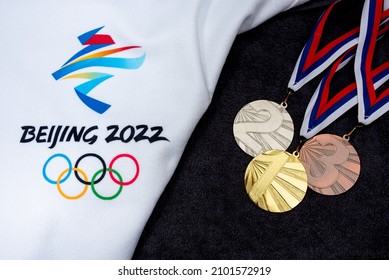 BEIJING, CHINA, JANUARY 1, 2022:  Gold, silver and bronze, medal set on snow, original wallpaper for winter olympic game in Beijing 2022. Black board.