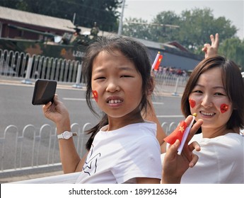 Beijing, China - October 1, 2018: Chinese Children With Flags Watching A Military Parade In The Capitol Beijing Celebrating The October 1 Anniversary Of Founding The People's Republic Of China In 1949