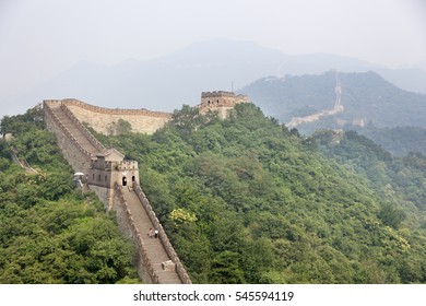 BEIJING, CHINA-AUGUST 17, 2010: Thousands Of Tourists Visit Daily The Chinese Wall. A Family Walking On The Great Wall Of China That The Horizon Is Lost In The Fog In Beijing On August 17, 2010