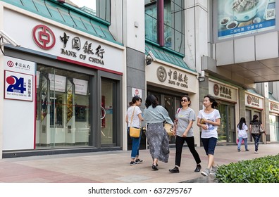 BEIJING, CHINA-MAY 1, 2017: Unidentified People Walk Past A Bank Of China Branch; Bank Of China (BOC) Is One Of The Five Biggest State-owned Commercial Banks Of China