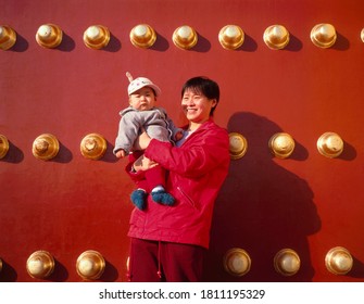 BEIJING, CHINA-NOVEMBER 13,2018: Mother and child posing for a photo at the entrance door of the Forbidden City