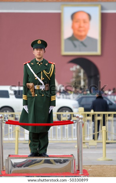BEIJING - FEB 19: a soldier stands guard in front of\
a portrait of Mao during spring festival on February 19, 2010 in\
Beijing, China. Crowds of people come to the capital to worship\
Mao