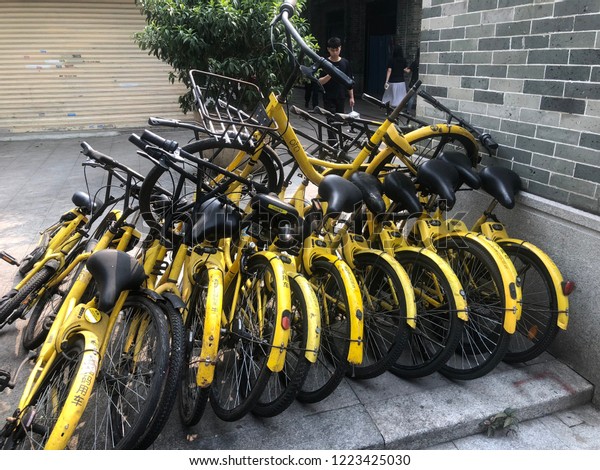 BEIJING LU, GUANGZHOU SHI, GUANGDONG CHINA -\
NOVEMBER 2018 : row of bicycles parked. Row of colorful bicycles.\
Rental yellow bicycles. Pattern of vintage bicycles bikes for rent\
on sidewalk.