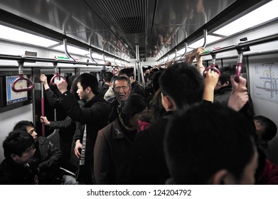 BEIJING - MARCH 15 2009:Crowded carrier of Beijing subway full of passengers.During  2019–20 coronavirus outbreak the Chines government closed tourist attractions to prevent mass gatherings.

