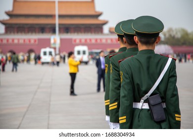 Beijing Tian'anmen Square guards standing still . The Chinese characters on the badge translates "military police" The characters on the wall are illegible 