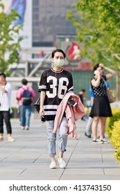 BEIJING-APRIL 28, 2016. Young Woman With A Mouth Cap. Despite Some Improvements In Worst Areas, Nearly 300 Chinese Cities Failed To Meet The National Air Quality Standards In 2015, Greenpeace Said.